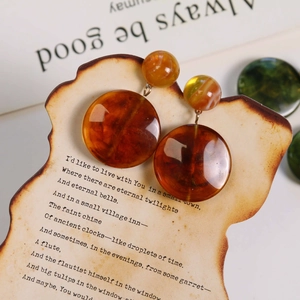 Detail of amber resin drop earring with marble texture on a vintage display card
