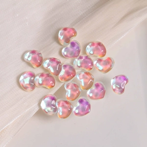 Macro detail of iridescent heart-shaped resin charms with pearl aurora coating for DIY