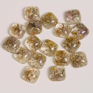 Flat lay of 16 square resin charms with real dried flowers and pearls for DIY jewelry