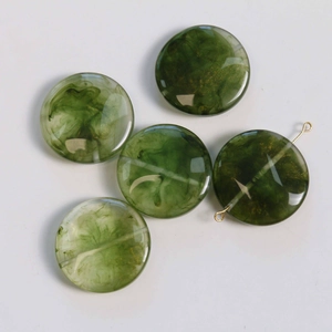 Detailed view of green marble smoke resin beads with gold flakes and horizontal drill holes