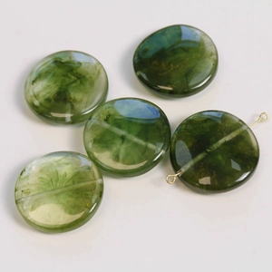 Close-up of green marble-pattern resin beads with smoky texture for DIY jewelry making