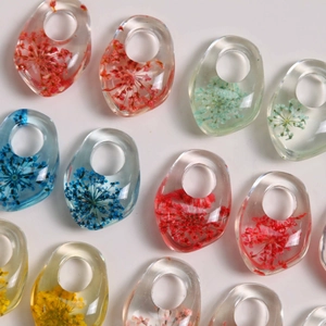 Close-up of irregular resin rings with embedded natural dried flowers for DIY jewelry