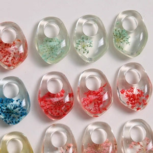 Macro shot of clear resin charms with real dried flowers in assorted vibrant colors