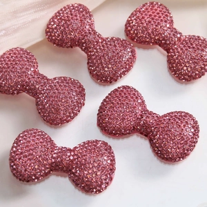 Macro detail of large pink rhinestone bow with intricate diamond setting for DIY crafts