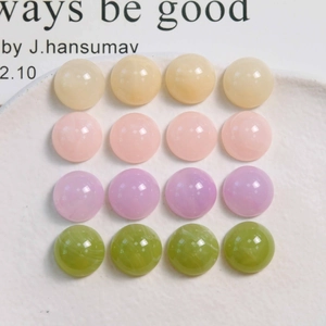 Détail macro de cabochons en résine 16mm aux quatre teintes pastel de macarons