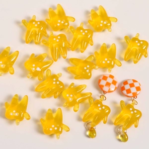 Close-up of yellow translucent resin tooth charms and handmade checkered earrings