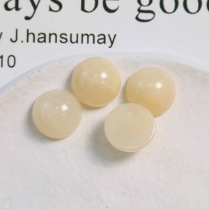 Vue macro de quatre perles rondes en résine crème de 16 mm pour bijoux DIY