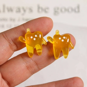 Close-up of a translucent amber resin tooth charm pendant for DIY jewelry making