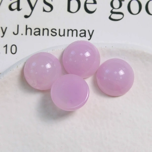 Vue macro de perles rondes en résine rose gelée de 16mm pour bijoux sur plateau blanc
