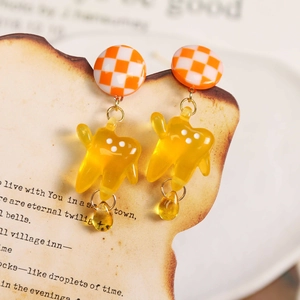 Translucent yellow tooth resin drop earrings with orange checkerboard studs on vintage card