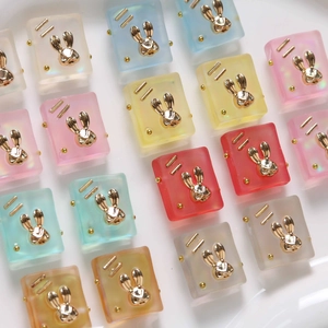 Macro view of gradient matte resin square charms with gold rabbit inlay for DIY jewelry