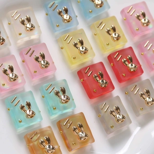 Macro view of gradient frosted resin square pendants with gold rabbit charms for DIY jewelry
