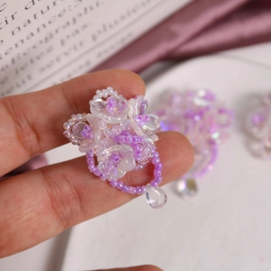 Macro detail of a handmade purple crystal flower cluster ring with transparent petals