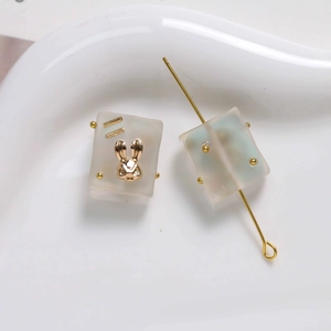 Close-up of matte gradient resin square beads with gold rabbit charms for DIY jewelry
