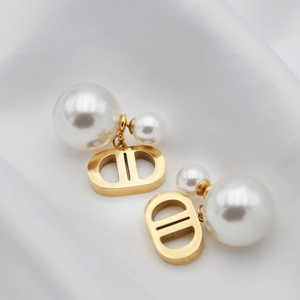 Boucles d'oreilles CD dorées de luxe avec élégantes doubles perles sur fond de soie