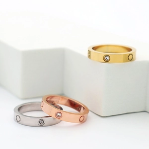 Macro view of gold, rose gold and silver band rings with screw motifs and small inset diamonds