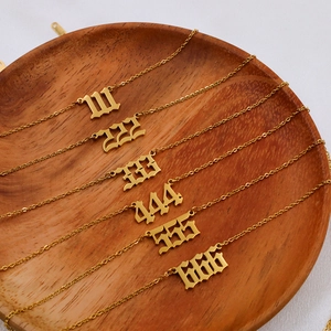 Goldene Engelszahlen-Halsketten 111-666 auf Holztablett mit feiner Gliederkette