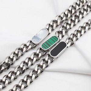 Detail of Cuban chain bracelets featuring white shell, malachite, and black onyx insets