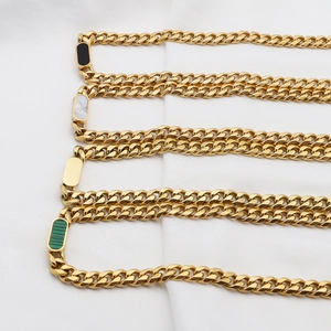 Detailed macro view of Cuban chain links with white shell and colorful inlaid rectangle stones