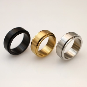 Tre anelli rotanti nei colori nero, oro e argento con finitura in metallo spazzolato