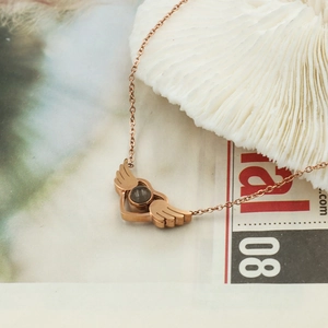 Macro shot of rose gold angel wing heart pendant with nano micro-carving projection stone