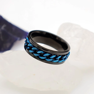 Detalle de anillo de titanio negro con cadena azul giratoria para aliviar el estrés