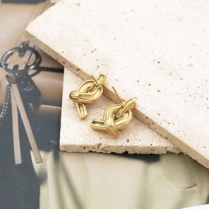 Eleganti orecchini a nodo in acciaio inossidabile placcato oro 18k su pietra di travertino