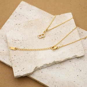 Macro view of gold letter B pendant with cubic zirconia and lobster clasp closure