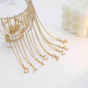 Detail of gold plated initial pendant necklaces with micro-paved cubic zirconia crystals