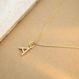 Close-up of gold-plated letter A pendant necklace with micro-pave white zircon crystals