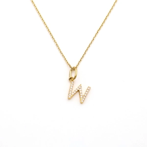 Detail of gold letter W pendant necklace with pavé cubic zirconia setting