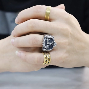 Detail of punk style rings featuring motorcycle motifs and inlaid black gemstones