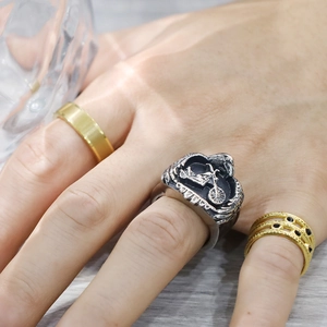 Detail of vintage motorcycle ring with gold bands and black stones on hand