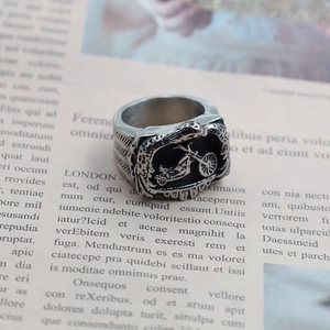 Retro punk motorcycle embossed stainless steel ring displayed on vintage newspaper