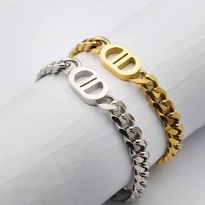 Elegante goldene und silberne Panzerarmbänder mit Doppel-D-Verschluss auf weißem Ständer