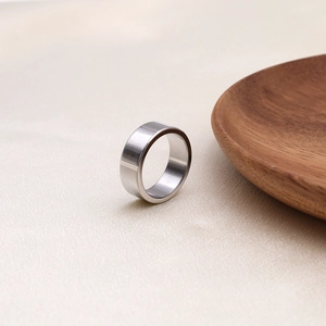 Macro detail of silver titanium steel ring on textured fabric with a wooden tray