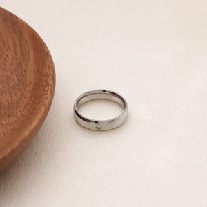 Gros plan d'une bague minimaliste en acier titane argenté avec zircon scintillant