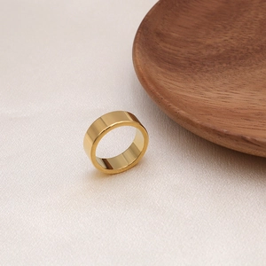 Polished 18K gold minimalist irregular steel ring shown on elegant silk fabric background