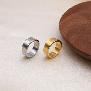 Close-up of gold and silver brushed titanium steel rings on beige silk fabric