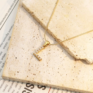 Detailansicht der vergoldeten Schlangenkette mit Perlen-besetztem Buchstaben-L-Anhänger
