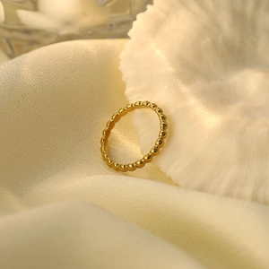 Nahaufnahme eines minimalistischen goldenen Perlenrings aus 316L Titanstahl