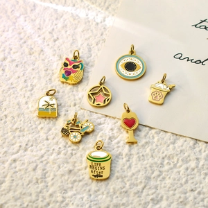 Macro view of eight colorful enamel DIY pendants including cat, coffee, and evil eye charms