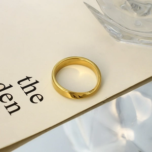 Gros plan d'une bague Mobius dorée avec anneau torsadé minimaliste sur support d'expo