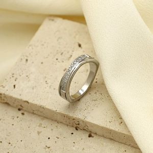 Detalle del anillo cruzado de acero inoxidable con pavé de circonitas brillantes