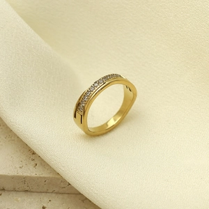 Vista macro detallada del anillo cruzado dorado con micro-pavé de circonitas cúbicas
