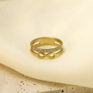 Détail macro d'une bague double couche dorée avec symbole infini et zircons blancs
