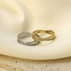 Detail of interlocking crisscross rings with paved crystals in gold and silver finish