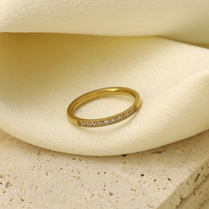 Anillo de acero de titanio dorado con diez circonitas micro-engastadas en seda crema