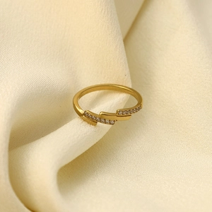 Three-layer gold titanium steel ring with sparkling cubic zirconia on silk background