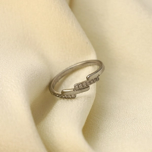 Three-layer silver stainless steel ring with zircon inlays on beige silk fabric